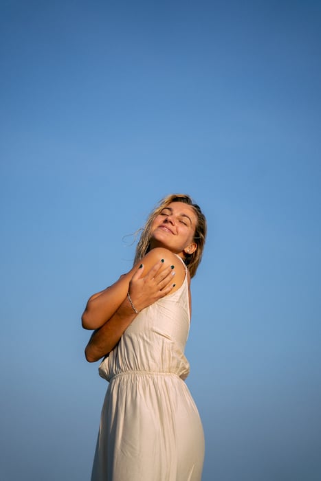 A Woman with Her Eyes Closed under a Blue Sky